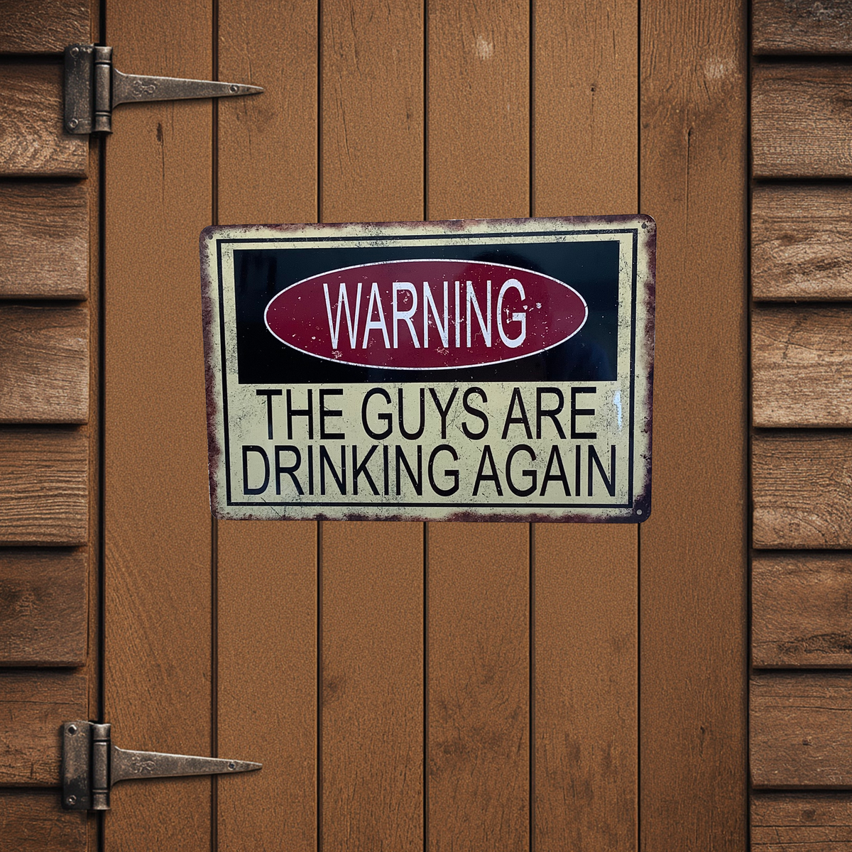 Distressed cream, black and red aluminum sign mounted on a wooden door, reading “Warning, the guys are drinking again.”