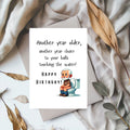 White rectangular birthday card with a cartoon older man sitting on a toilet, reading “Another year older, another year closer to your balls touching the water! Happy Birthday!”
