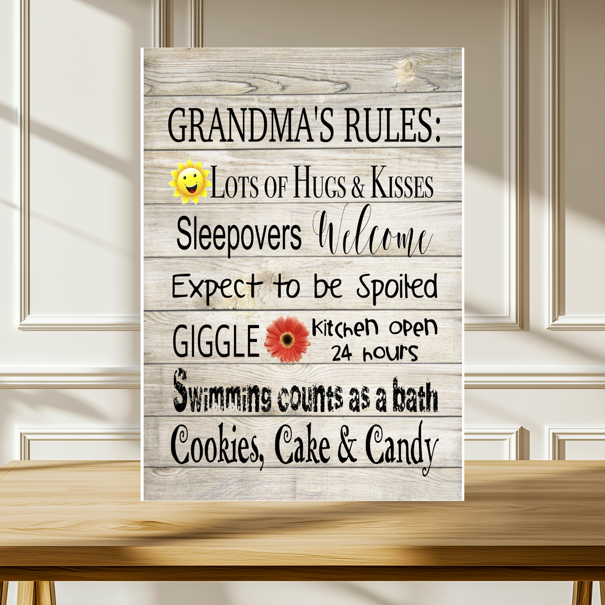 White wood-look aluminum sign with a smiling sun and flower, reading “Grandma’s Rules: Lots of hugs & kisses. Sleepovers welcome. Expect to be spoiled. Giggle. Kitchen open 24 hours. Swimming counts as a bath. Cookies, cake & candy.”