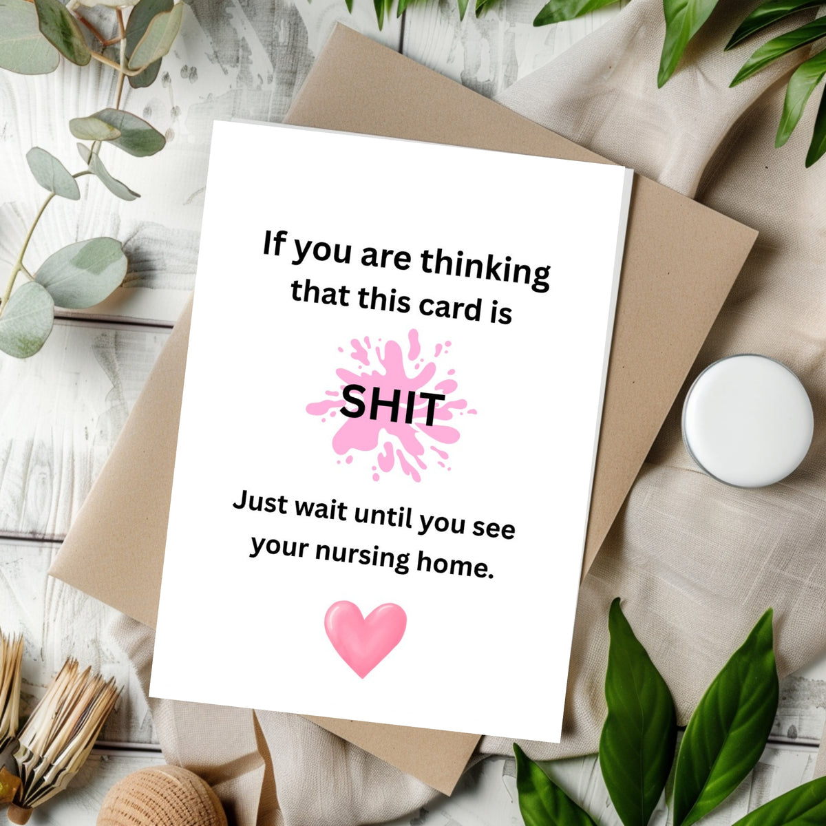 White rectangular card with a pink splatter and heart, reading “If you are thinking that this card is shit, just wait until you see your nursing home.”