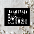 Black aluminum sign reading “The Ass Family,” with white cartoon family members and a dog labelled “Jack,” “Smart,” “Lazy,” “Kiss,” “Dumb” and “Lick.”