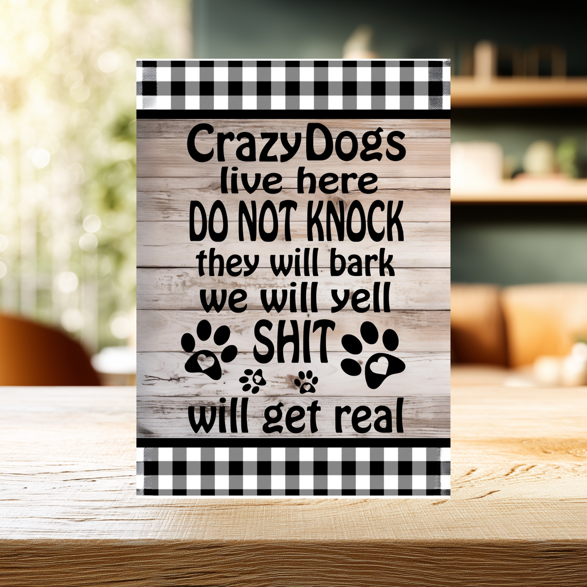 Wood-look aluminum sign with black-and-white checked borders and paw prints, reading “Crazy dogs live here. Do not knock. They will bark, we will yell, shit will get real.”