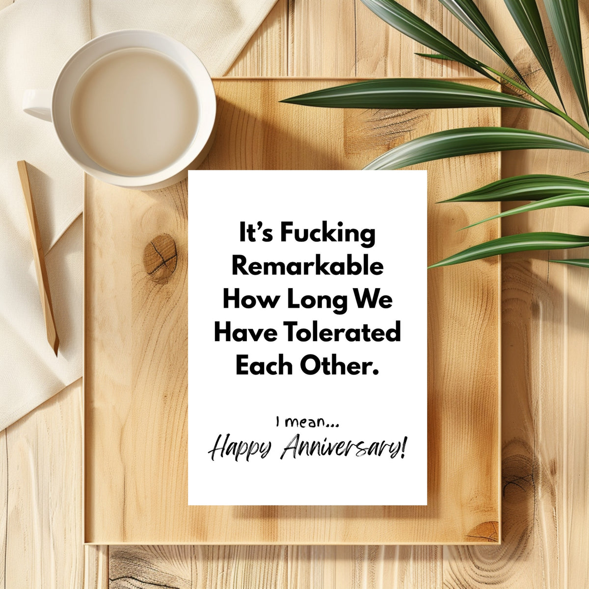 White rectangular card with black lettering reading “It’s fucking remarkable how long we have tolerated each other. I mean... Happy Anniversary!”