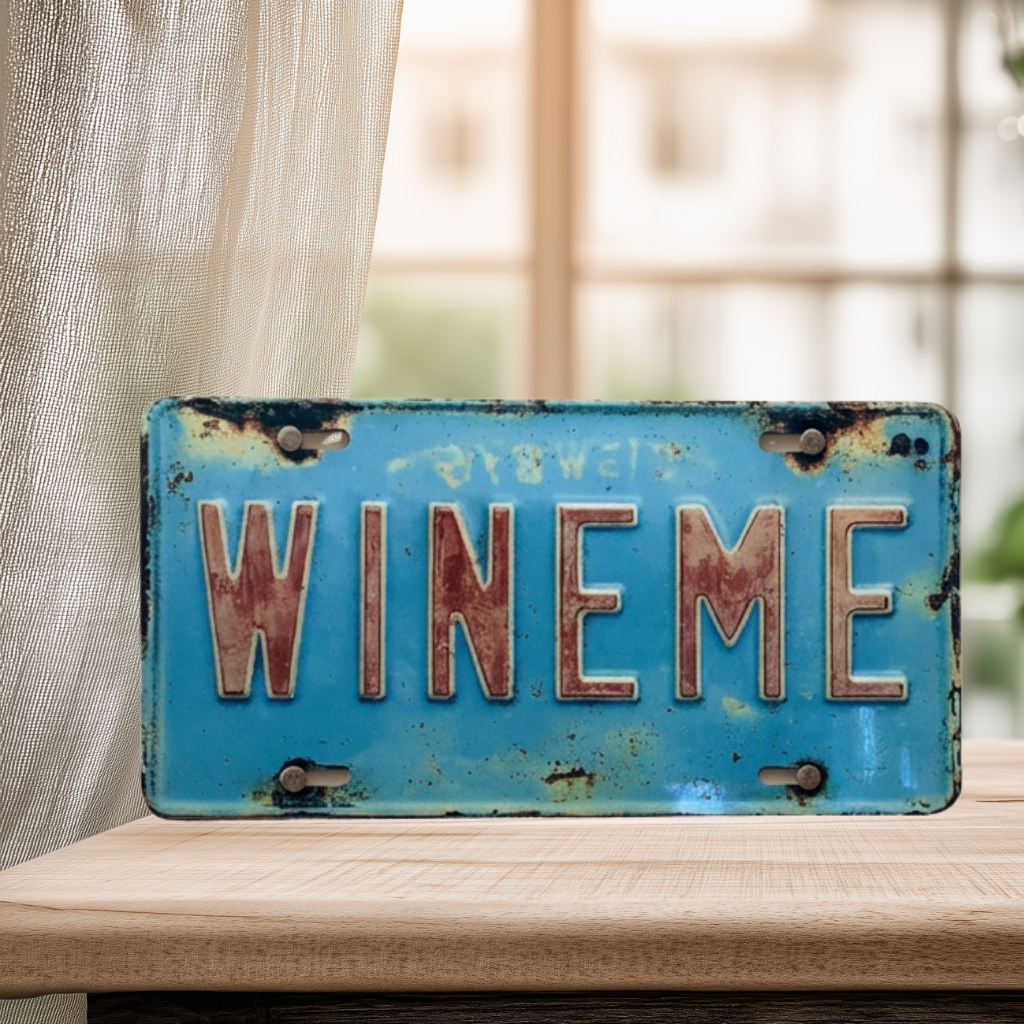 Distressed turquoise faux license plate sign with large faded red lettering reading “Wine Me.”